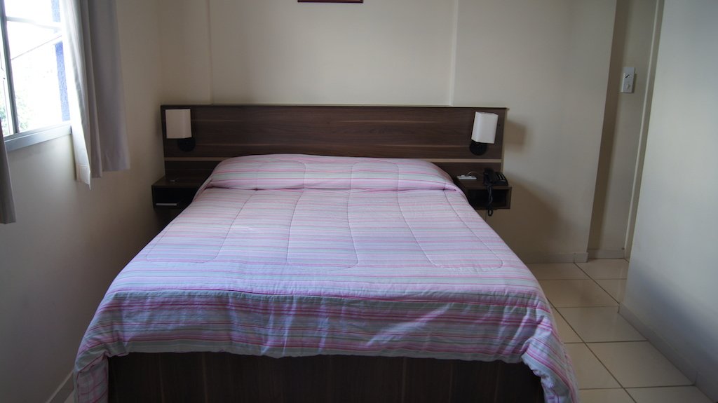 Quarto para casal do Astro Hotel com a cama em destaque